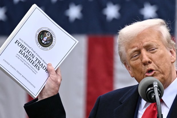 Donald Trump delivers remarks on reciprocal tariffs during the ‘Make America Wealthy Again’ event at the the White House on 2 April 2025. Photograph: Brendan Smialowski/AFP/Getty Images