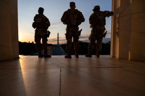 The Washington Monument is seen in the distance as members of the National Guard stand atop the steps at the Lincoln Memorial at sunrise on the National Mall in Washington, DC, on July 23, 2026. Kent Nishimura/AFP via Getty Images