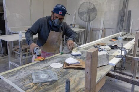 A stone-countertop fabricator at a Sun Valley shop wears a mask to help protect against airborne particles that can contribute to silicosis in October 2023. (Brian van der Brug / Los Angeles Times)