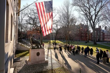 FILE - People take photos near a John Harvard statue, left, on the Harvard University campus, Jan. 2, 2024, in Cambridge, Mass. Steven Senne/AP