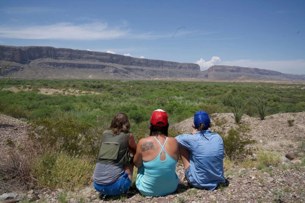 A group of local residents tearfully watch bulldozers go to work deep in the brush near the Rio Grande in Big Bend National Park. Ashley Killough/CNN