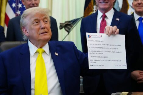 President Donald Trump holds up a print-out of one of his Truth Social posts at an Oval Office event in June. (Julia Demaree Nikhinson/AP)